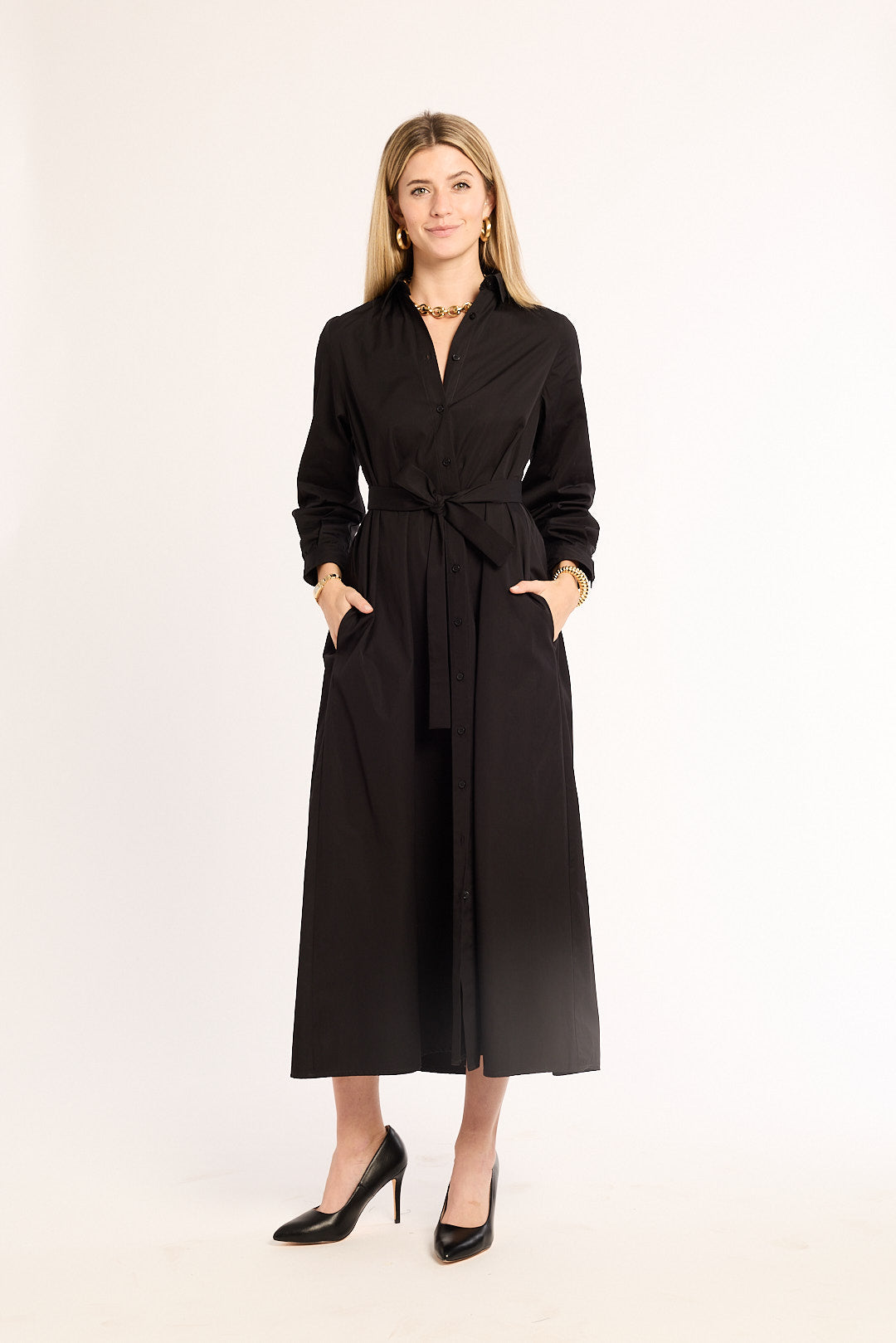 Woman wearing a black dress with a belt on a white background