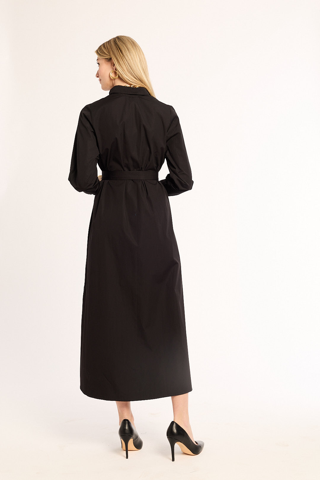 Woman wearing a black dress with a belt on a white background