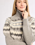 Woman wearing a patterned sweater against a plain background