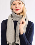Woman wearing a gray knit hat and scarf on a white background