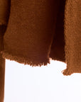 Close-up of a brown textured fabric with a white background