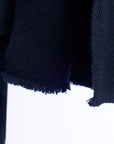 Close-up of a dark blue sweater with frayed edges on a white background