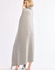 Woman wrapped in a long gray blanket on a white background