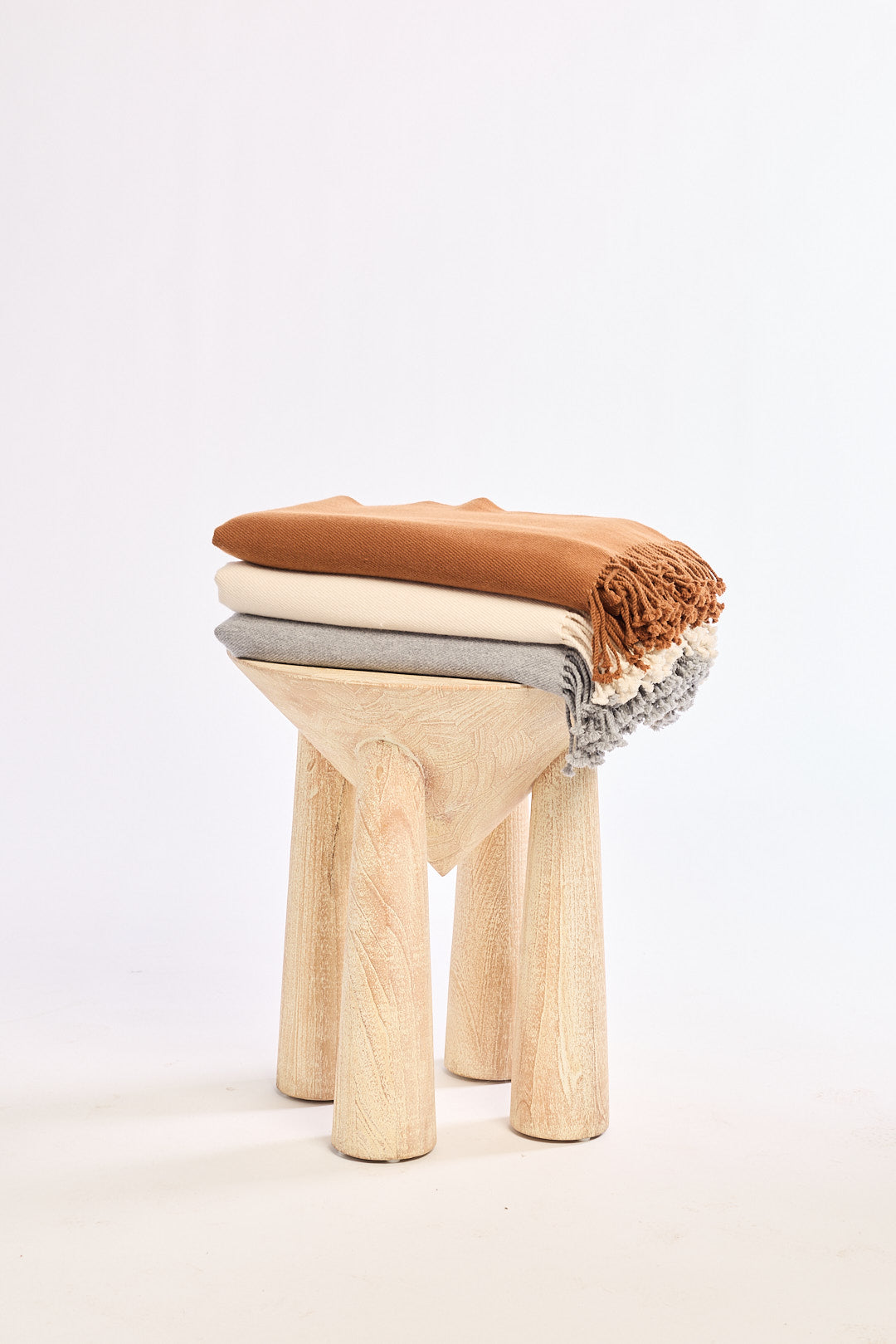 Wooden stool with three cushioned seats stacked on a white background