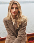 Woman modeling a tweed blazer on a boat outside