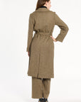 A woman modeling the belted Painter's Fleck Herringbone Anne Coat with matching trousers, back view, photographed against a plain white studio background.