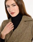 Close-up of the lapel and flecked brown herringbone texture of the Anne Coat layered over a black turtleneck, photographed against a plain white studio background.