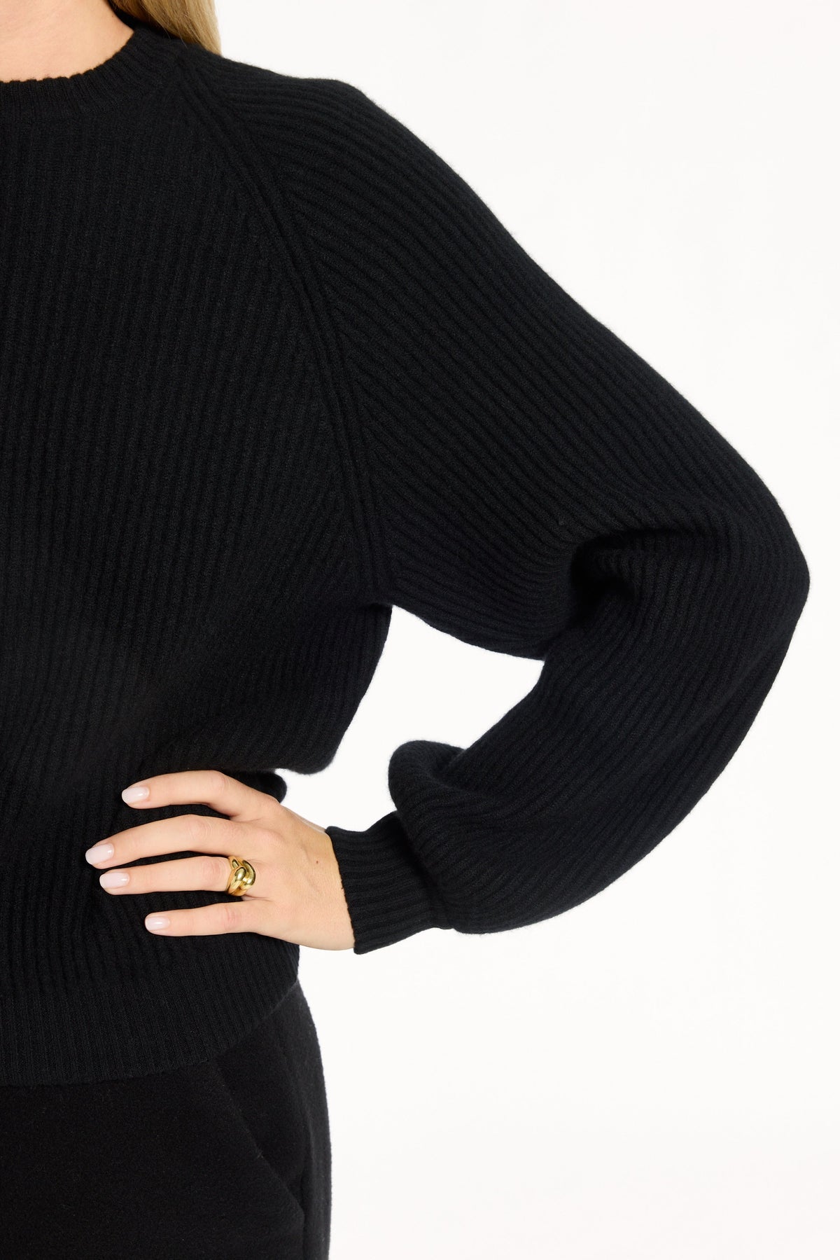 Close-up of the balloon sleeve, ribbed cuff, and knit texture of the black Baby Cashmere Ribbed Crewneck, photographed against a plain white studio background.