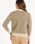 A woman modeling the Camel Tri-Color Check Classic Cashmere Cardigan with camel trousers, back view, photographed against a plain white studio background.