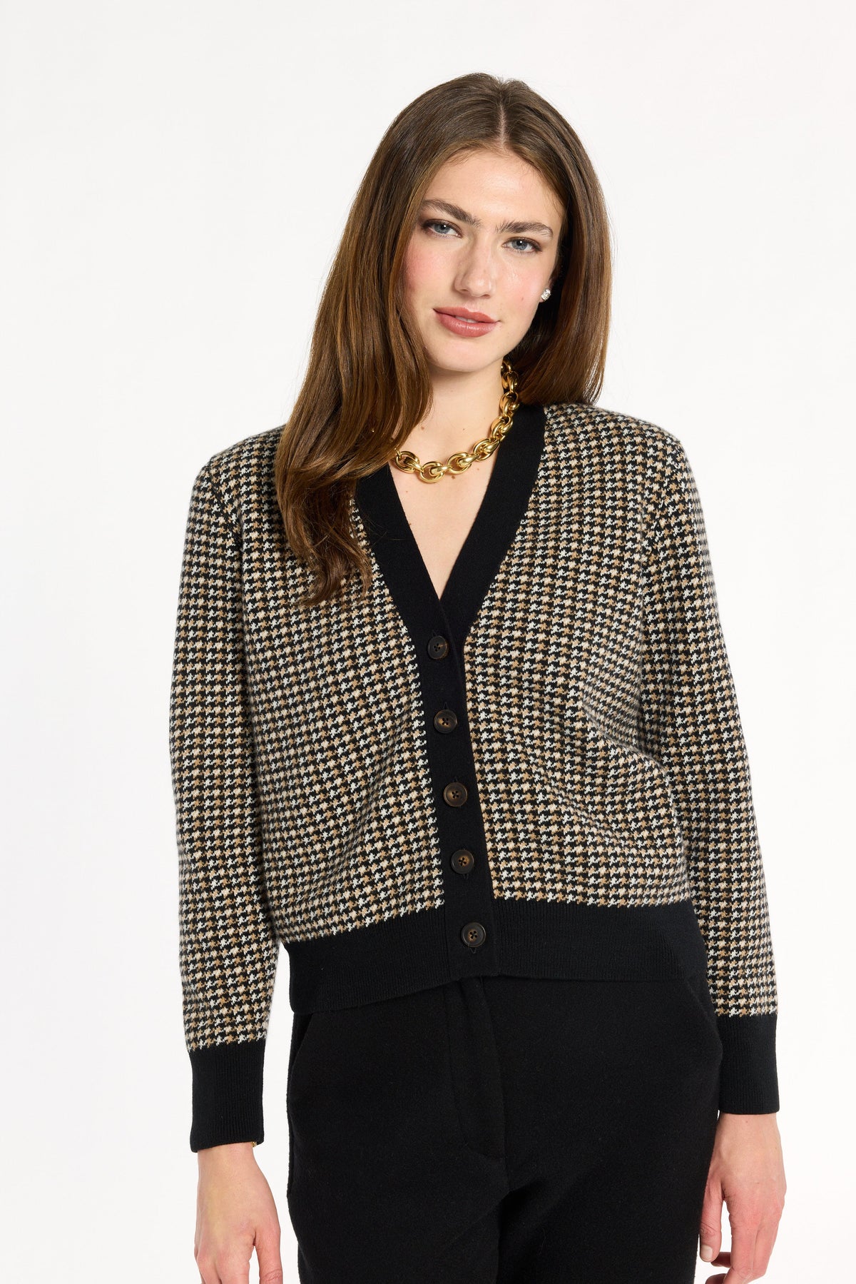 A woman modeling the Black Tri-Color Check Classic Cashmere Cardigan with black trousers, front view, photographed against a plain white studio background.