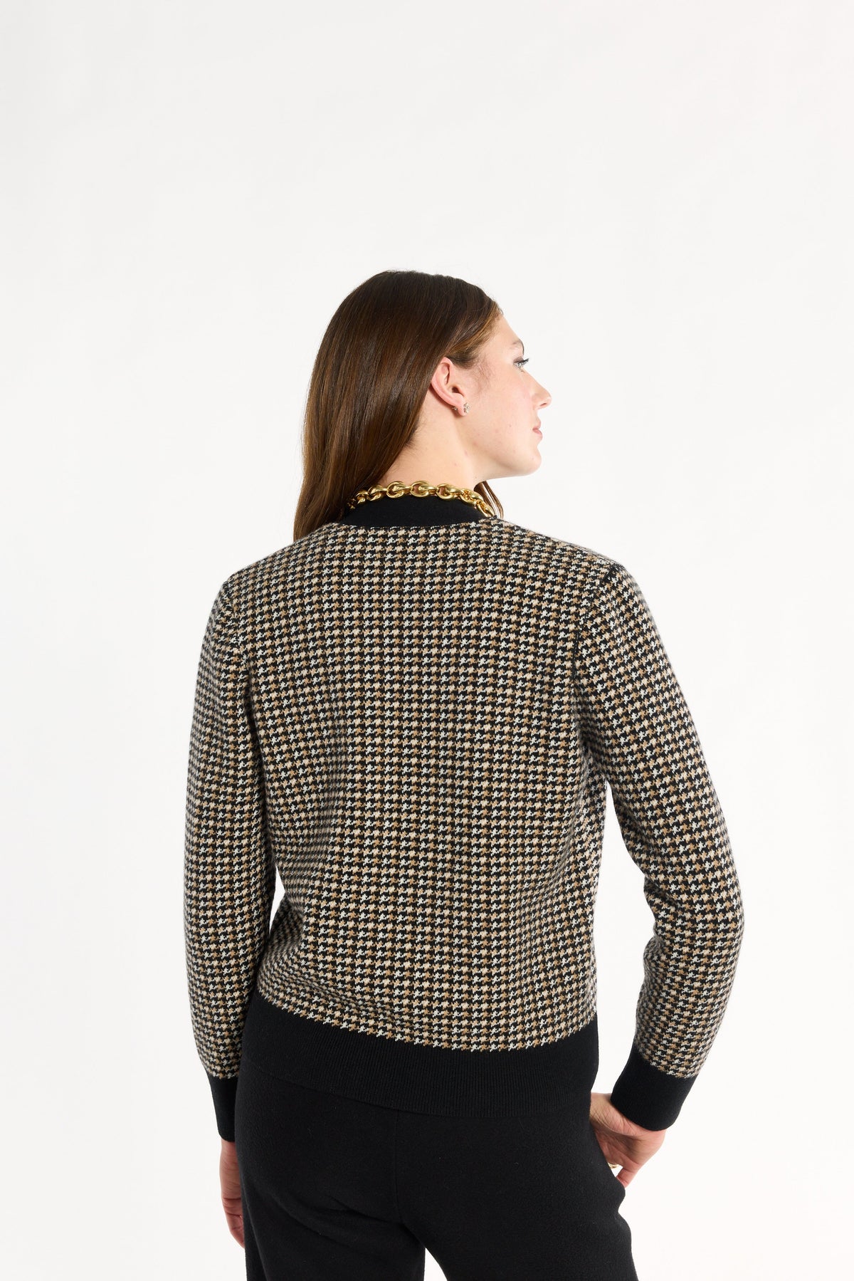 A woman modeling the Black Tri-Color Check Classic Cashmere Cardigan with black trousers, back view, photographed against a plain white studio background.