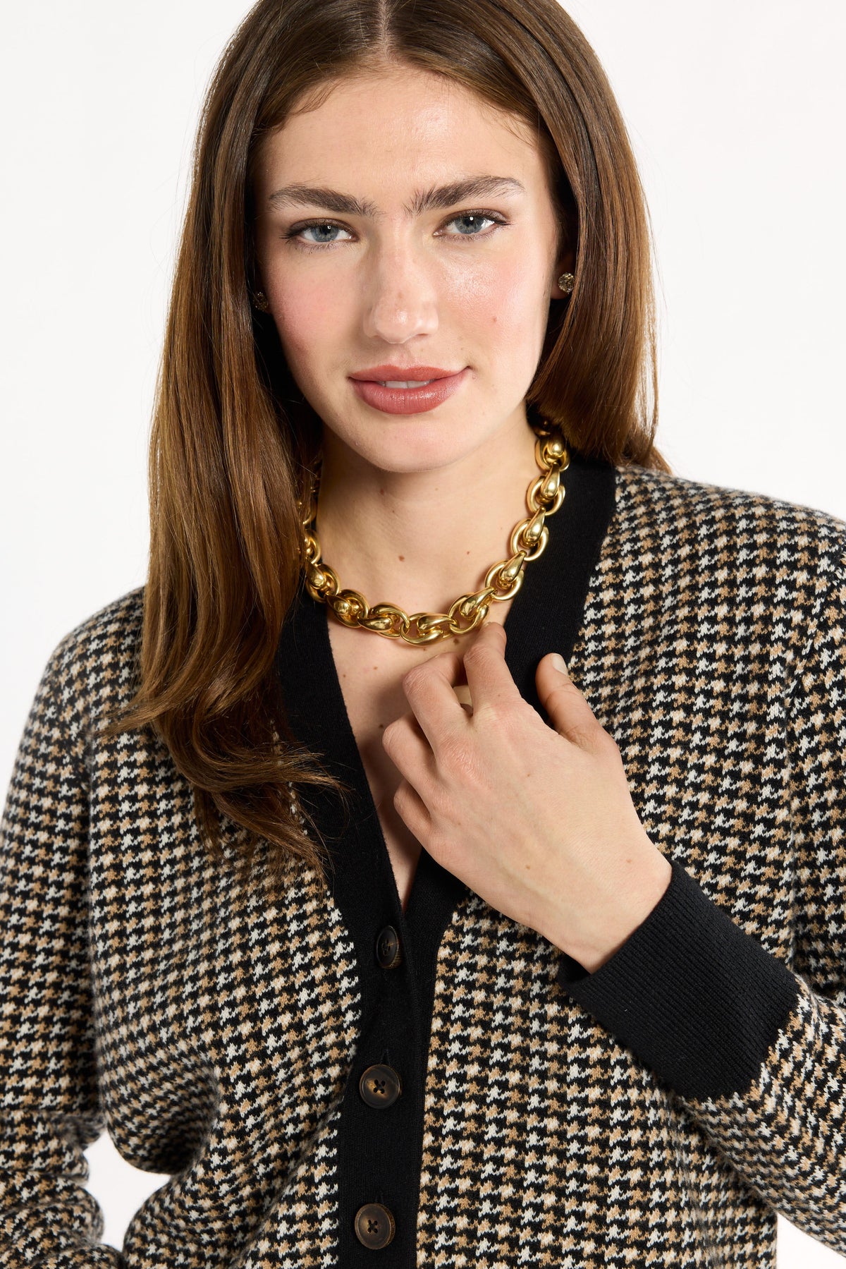 Close-up of the black trim, horn buttons, and check pattern of the Black Tri-Color Check Classic Cashmere Cardigan, photographed against a plain white studio background.
