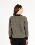 A woman modeling the Black Tri-Color Check Classic Cashmere Crew with black trousers, back view, photographed against a plain white studio background.
