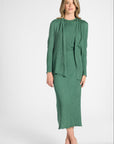 Woman modeling a sage green cardigan with buttons on sleeve on a white backdrop