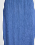 A close-up of a blue vertically ribbed or pleated fabric texture, showing the material detail and color.