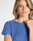 Close up image of a pleated blue dress with gemstones on the shoulder