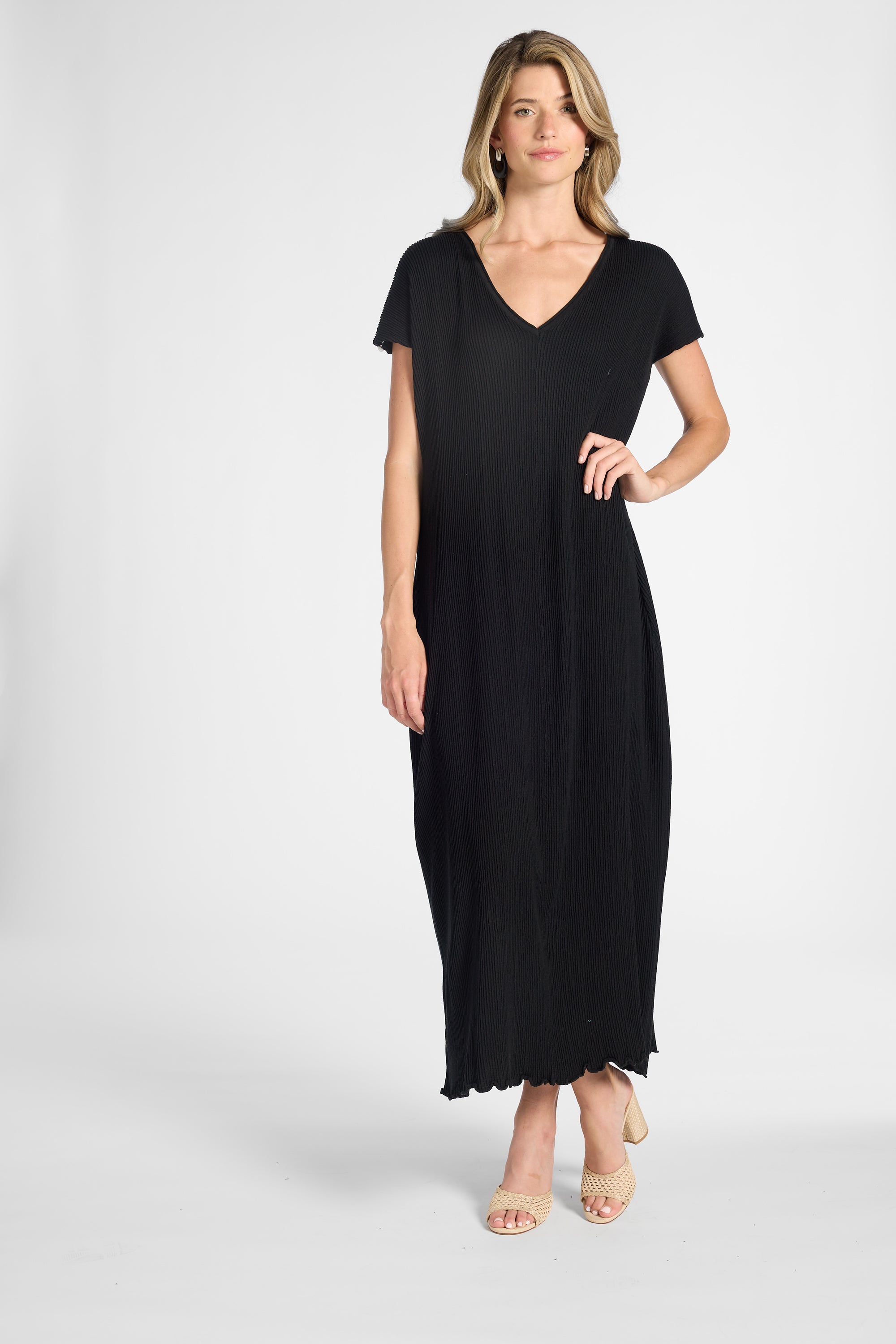 Woman modeling a v-neck silk pleated dress on a white background