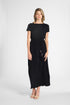 Woman modeling a pleated black silk dress with a tassel around the waist on a white backdrop