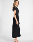 A woman modeling a pleated black dress on a white background