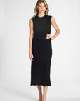 Woman modeling a pleated black shell with the matching skirt on a white backdrop