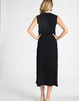 A woman shown from the back wearing a black skirt, standing against a light gray studio background.