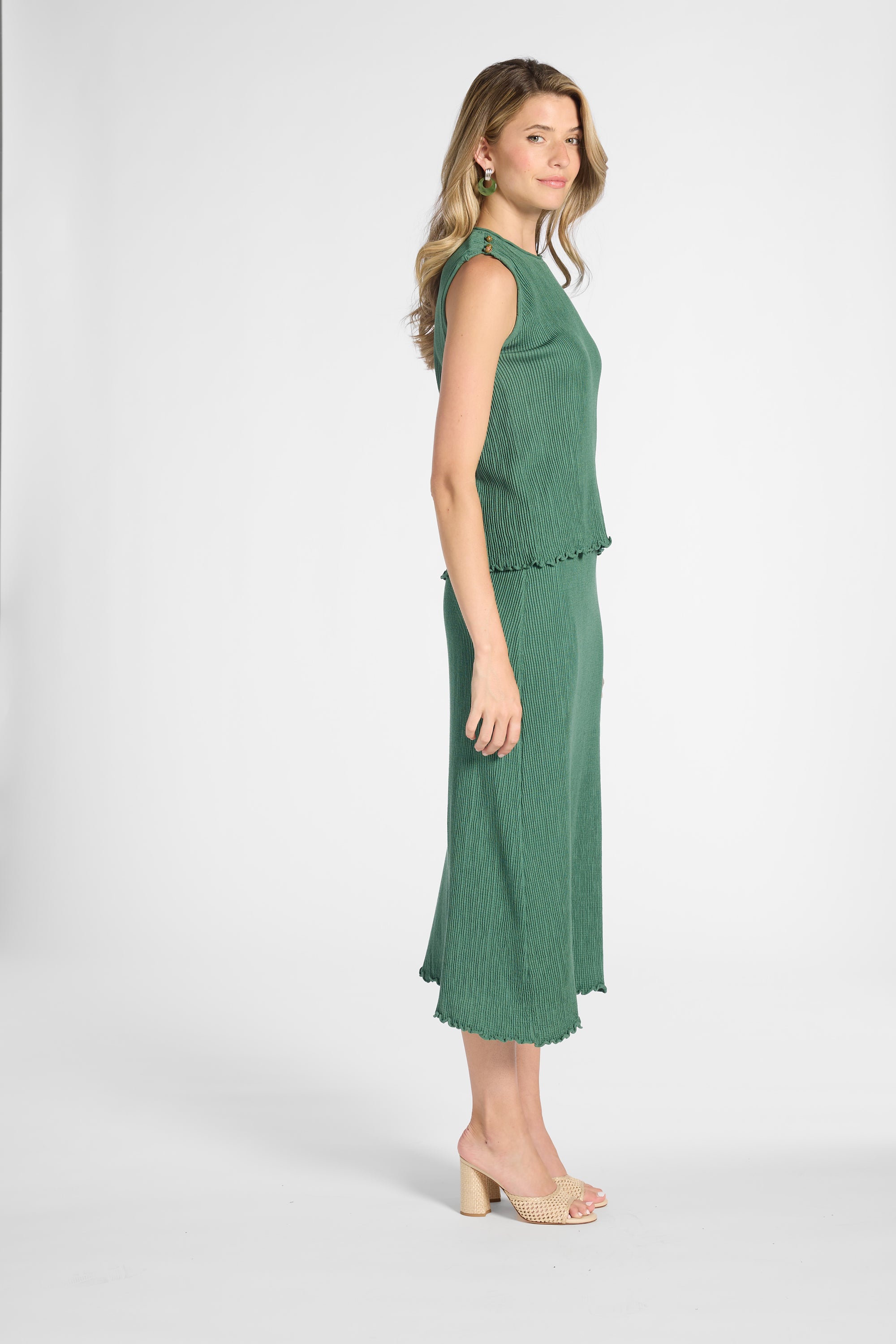 Woman modeling a pleated shell with the matching skirt on a white backdrop