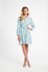 Woman wearing a light blue patterned dress on a white background