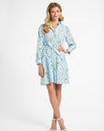 Woman wearing a light blue patterned dress on a white background