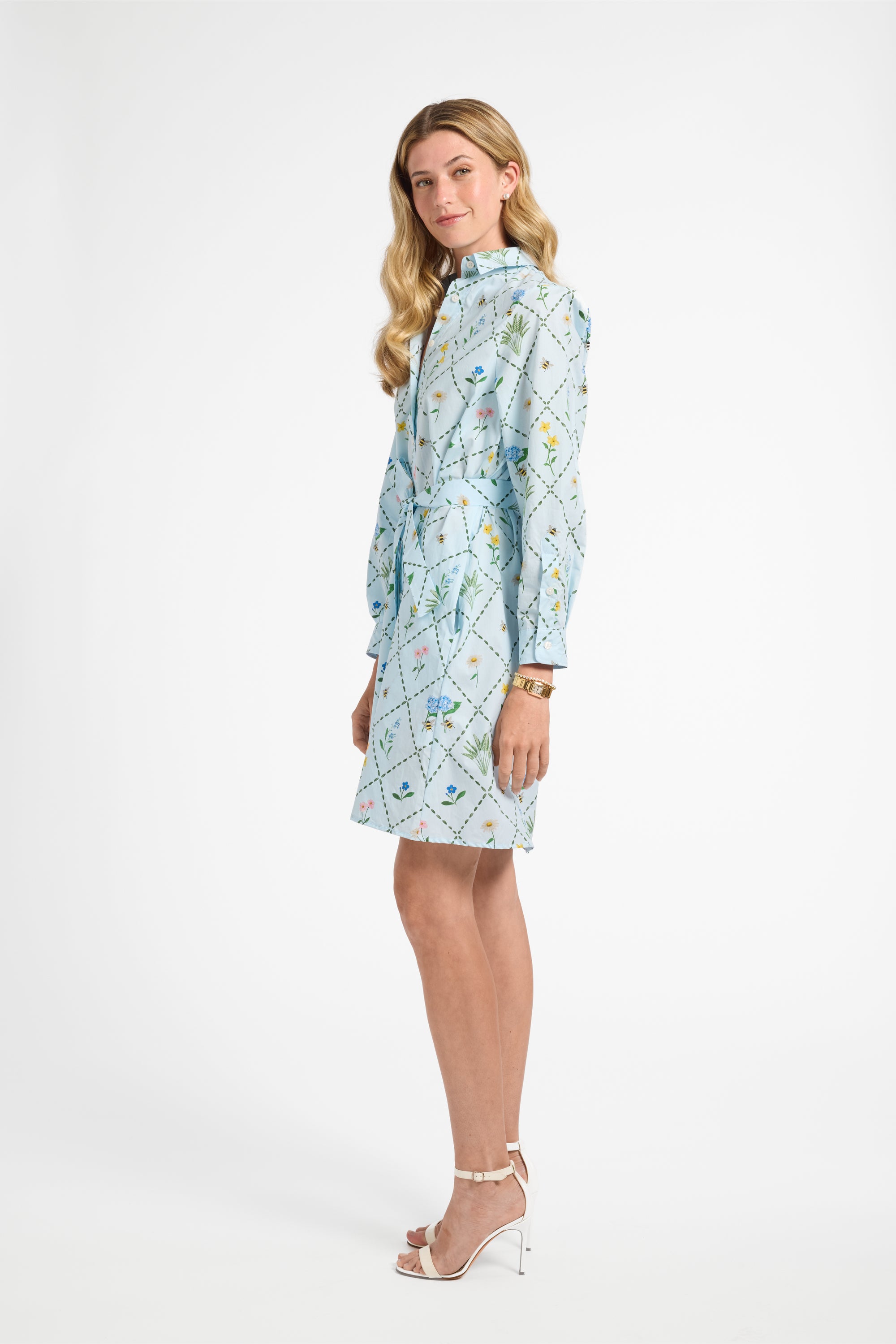 Woman modeling a blue floral mid length dress on a white backdrop