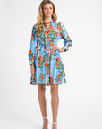 Woman wearing a blue striped dress with oranges on a white backdrop