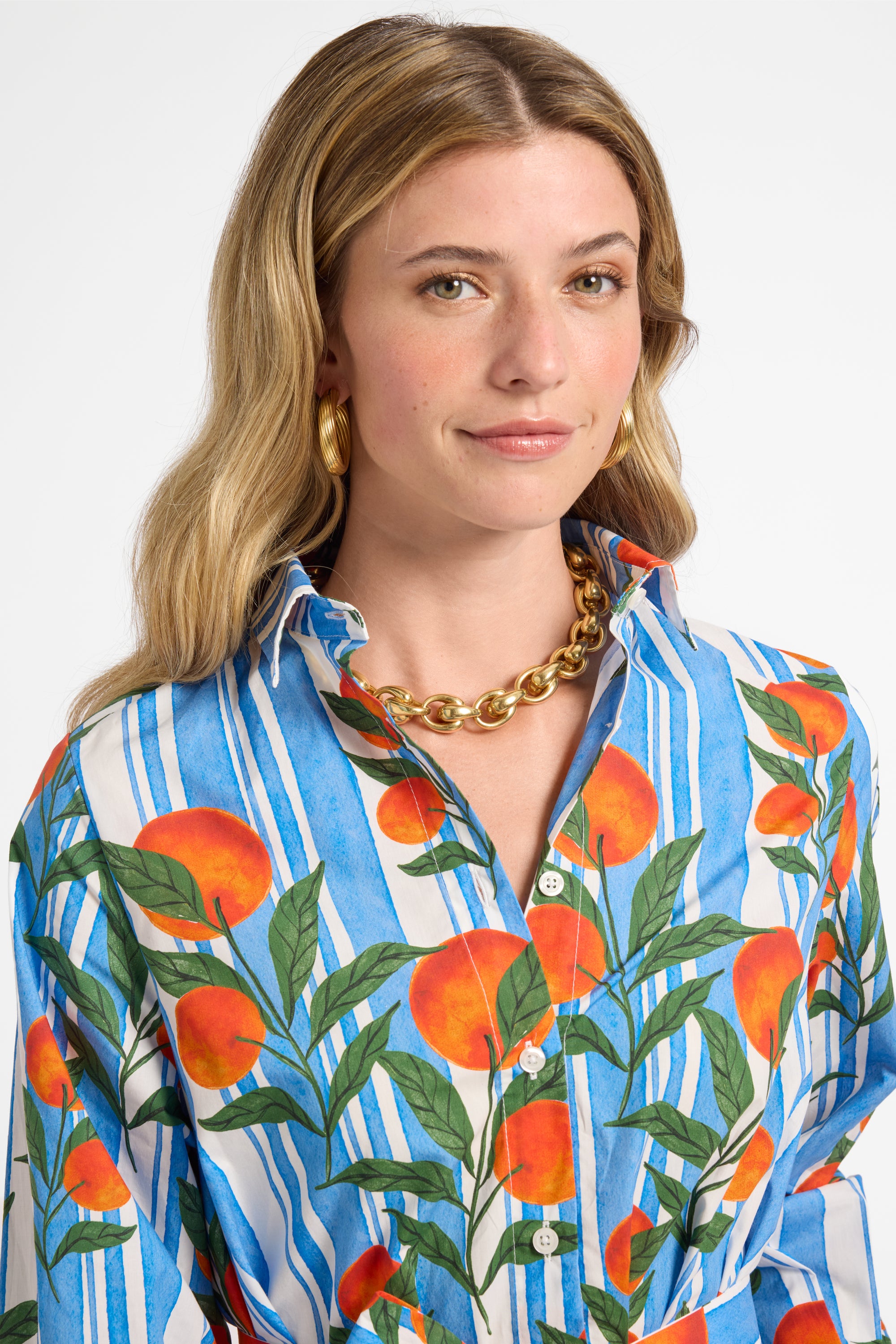 Woman wearing a colorful shirt with orange pattern on a white background