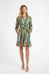 Woman modeling a green striped dress with oranges on a white backdrop