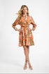 Woman wearing an orange and white striped dress with a floral pattern on a white background