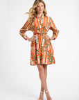 Woman wearing an orange and white striped dress with a floral pattern on a white background