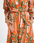 Orange and white striped dress with fruit pattern on a plain background