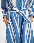 Blue and white striped dress with a tie around the waist on a plain background