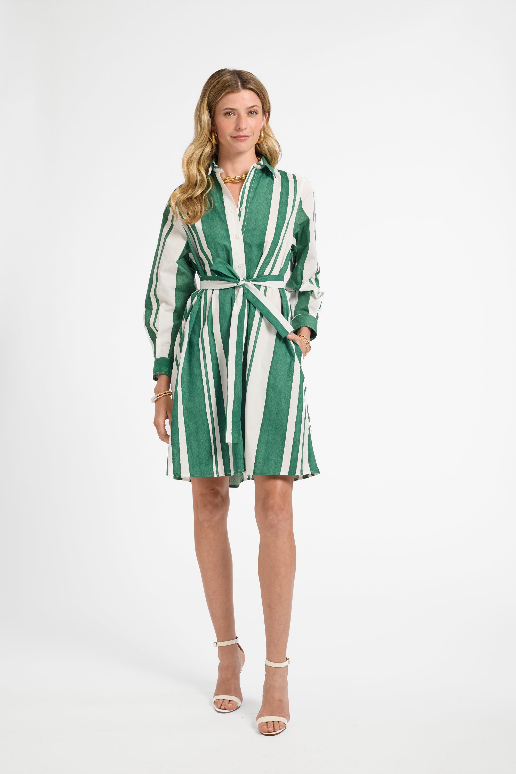 Woman wearing a green and white striped dress on a white background