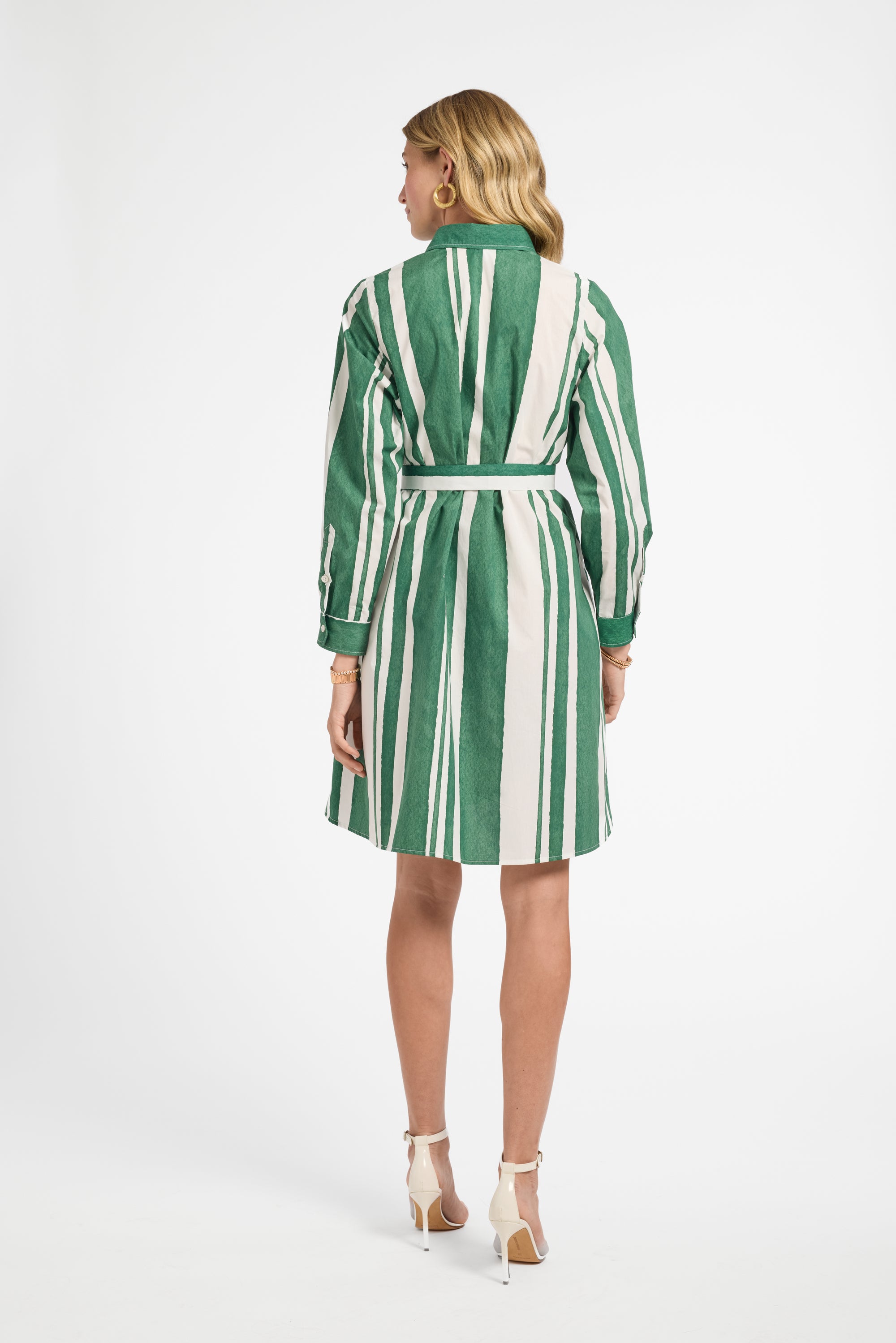 Woman wearing a green and white striped dress on a white background