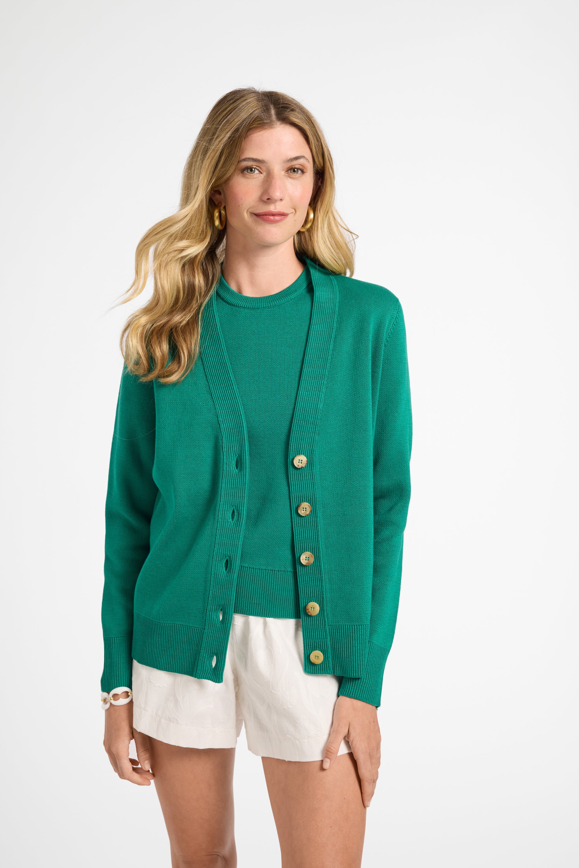 Woman wearing a green cardigan with buttons on a white background