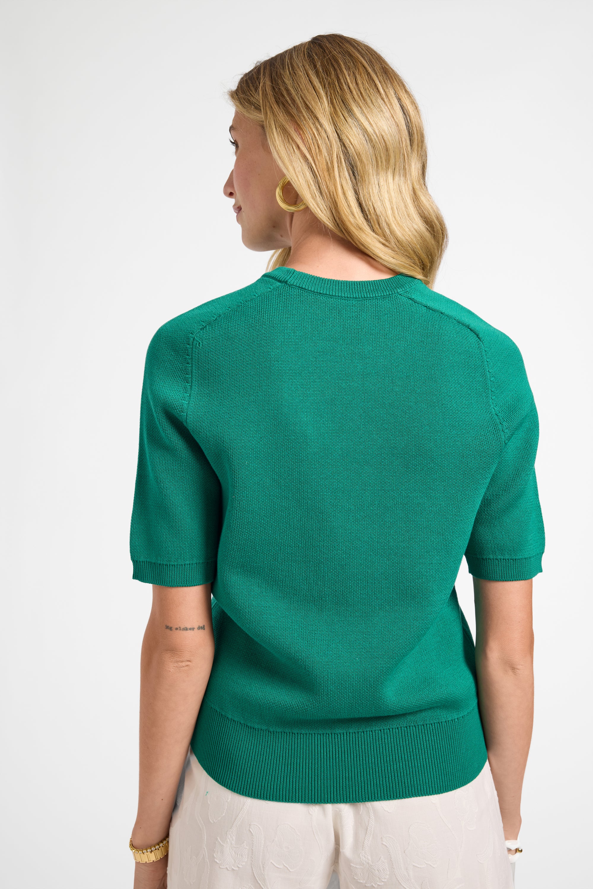 Woman wearing a green sweater on a white background