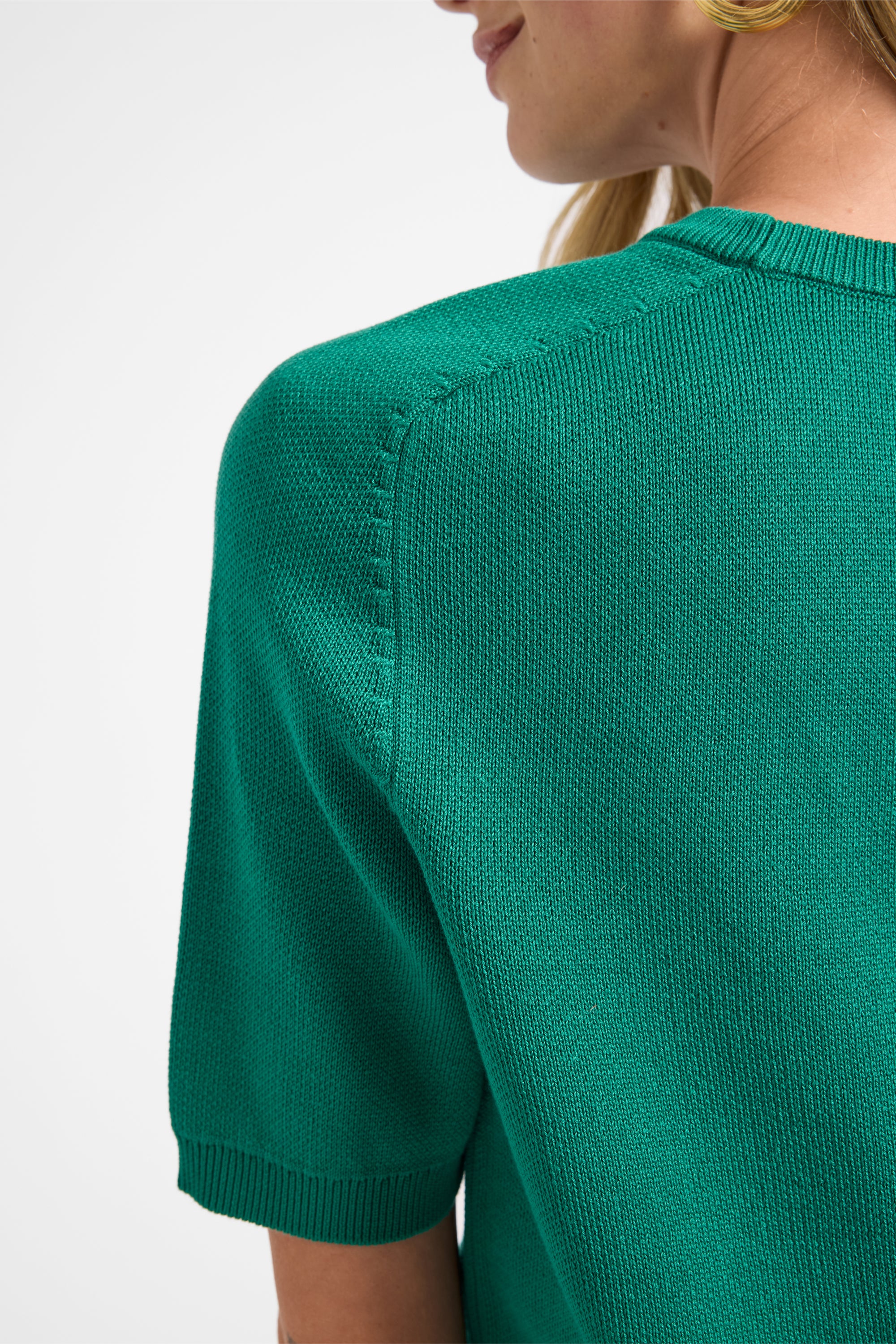 Close up of green cotton material on a white backdrop