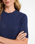 Woman wearing a navy blue cotton t-shirt with a plain background
