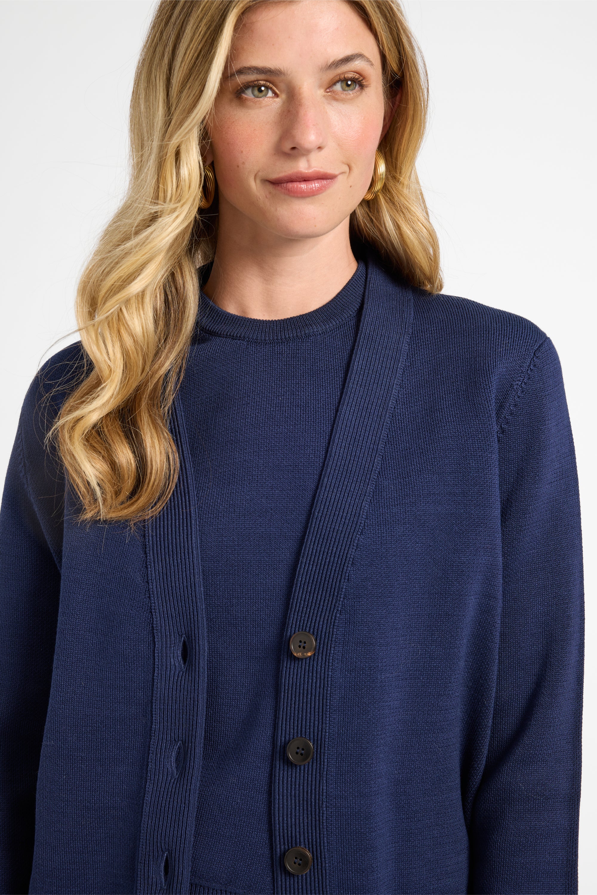 Woman wearing a blue cardigan against a white background