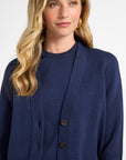 Woman wearing a blue cardigan against a white background