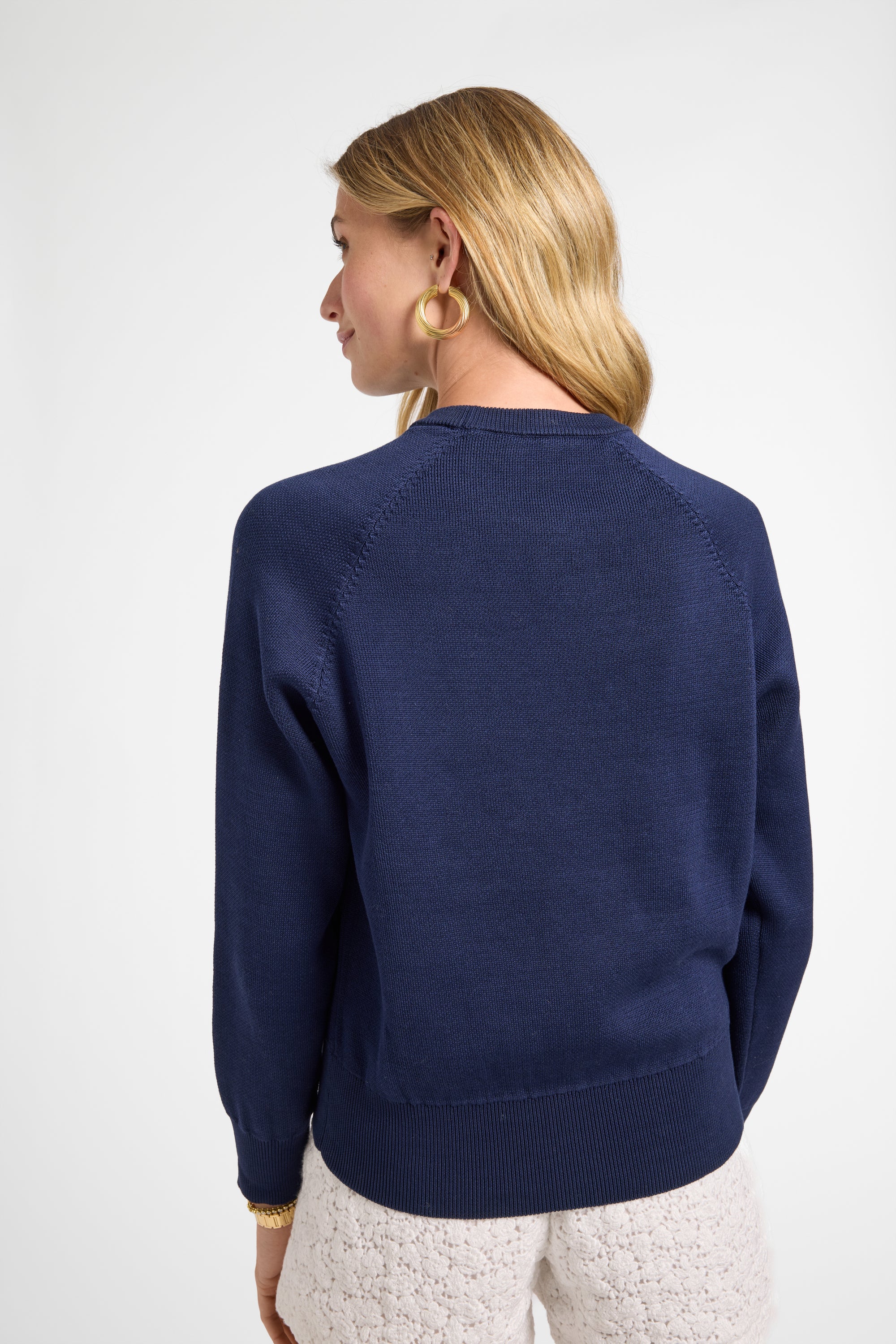 Woman wearing a navy blue sweater on a white background