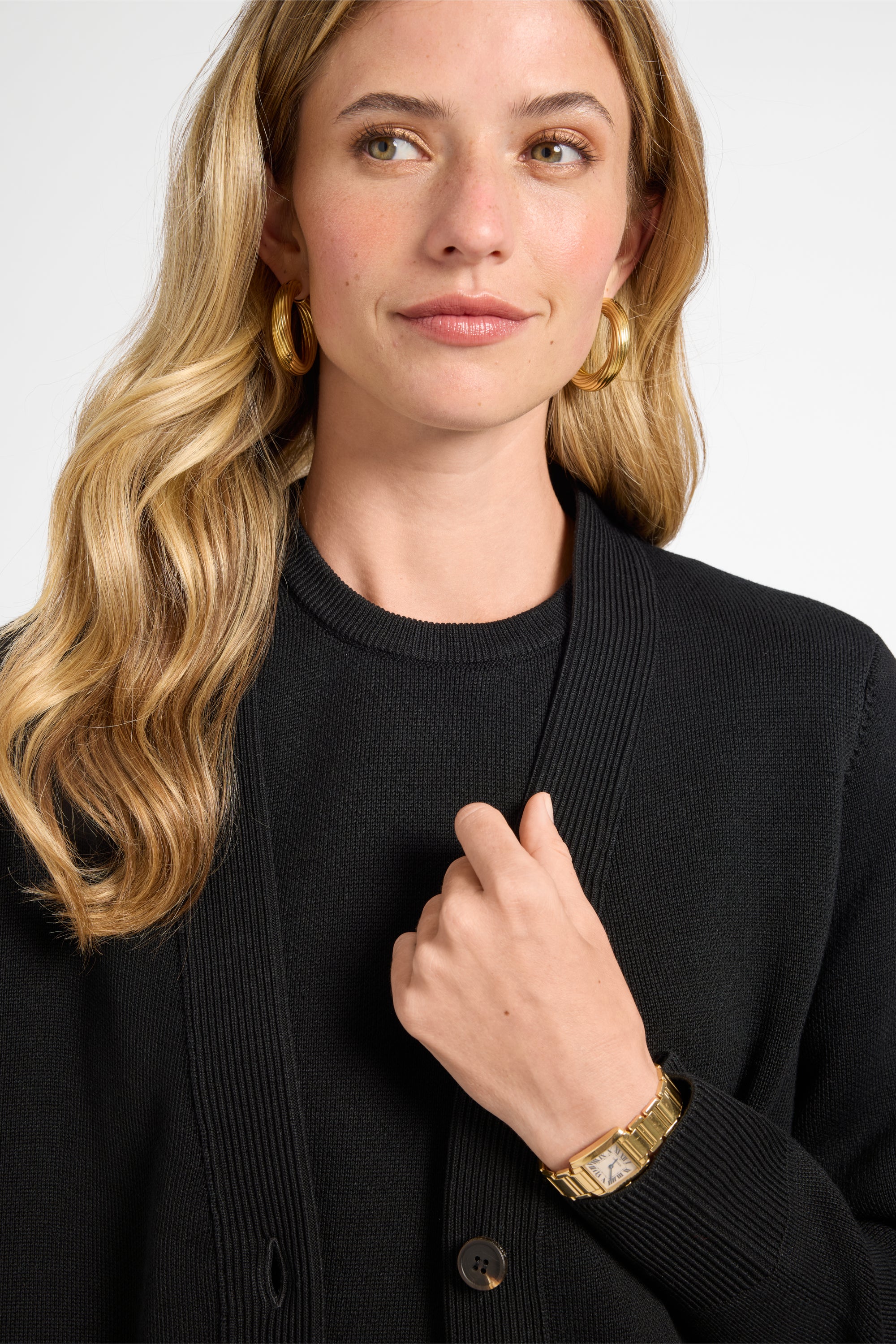 Woman wearing a black cardigan with a plain background