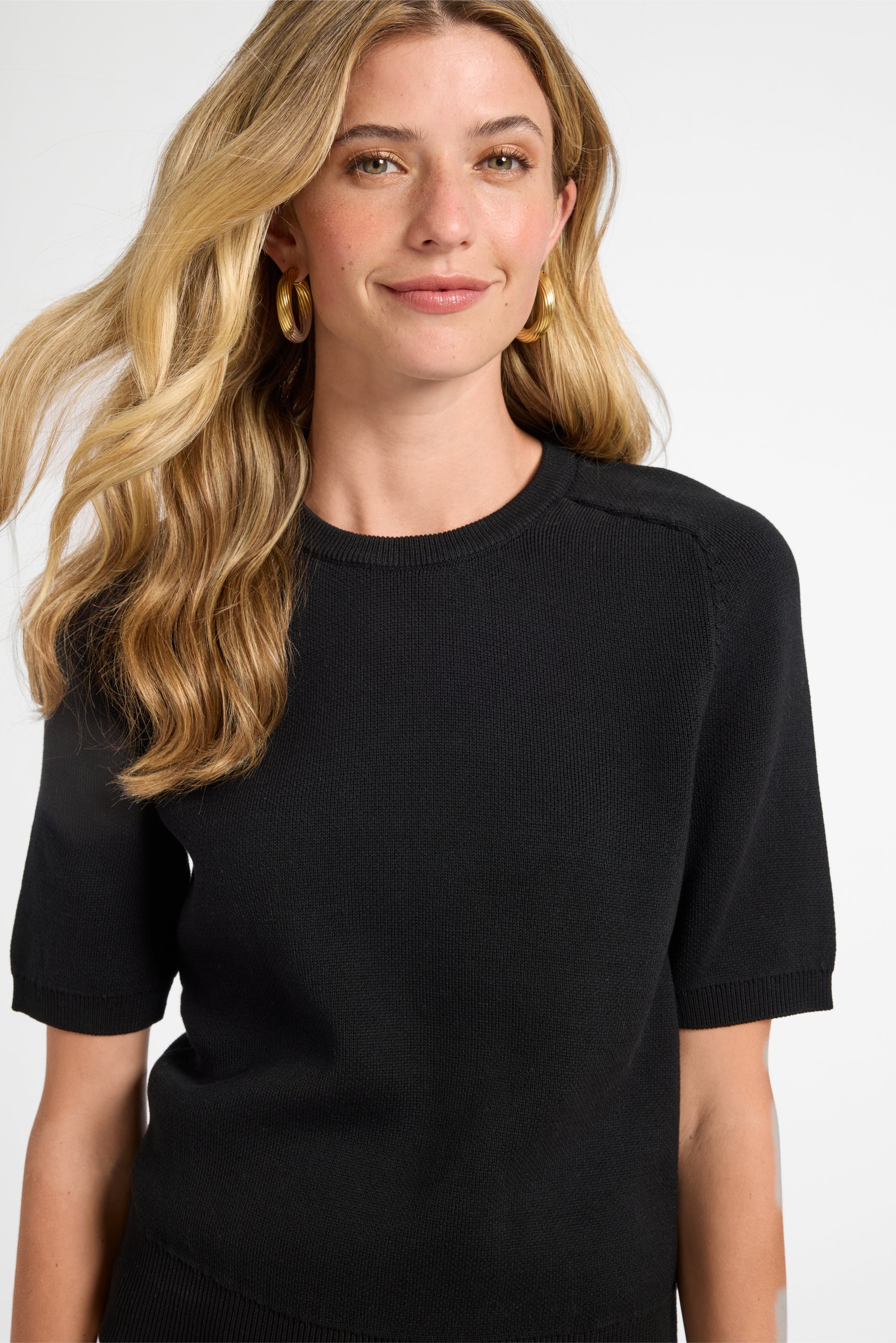 Woman wearing a black t-shirt against a white background