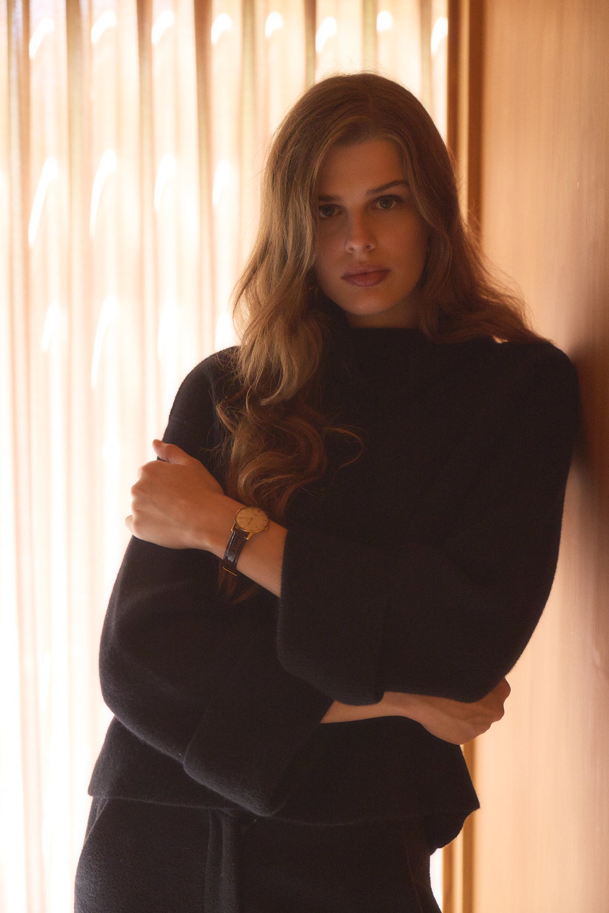 Woman standing in a house wearing the black turtleneck cashmere sweater 
