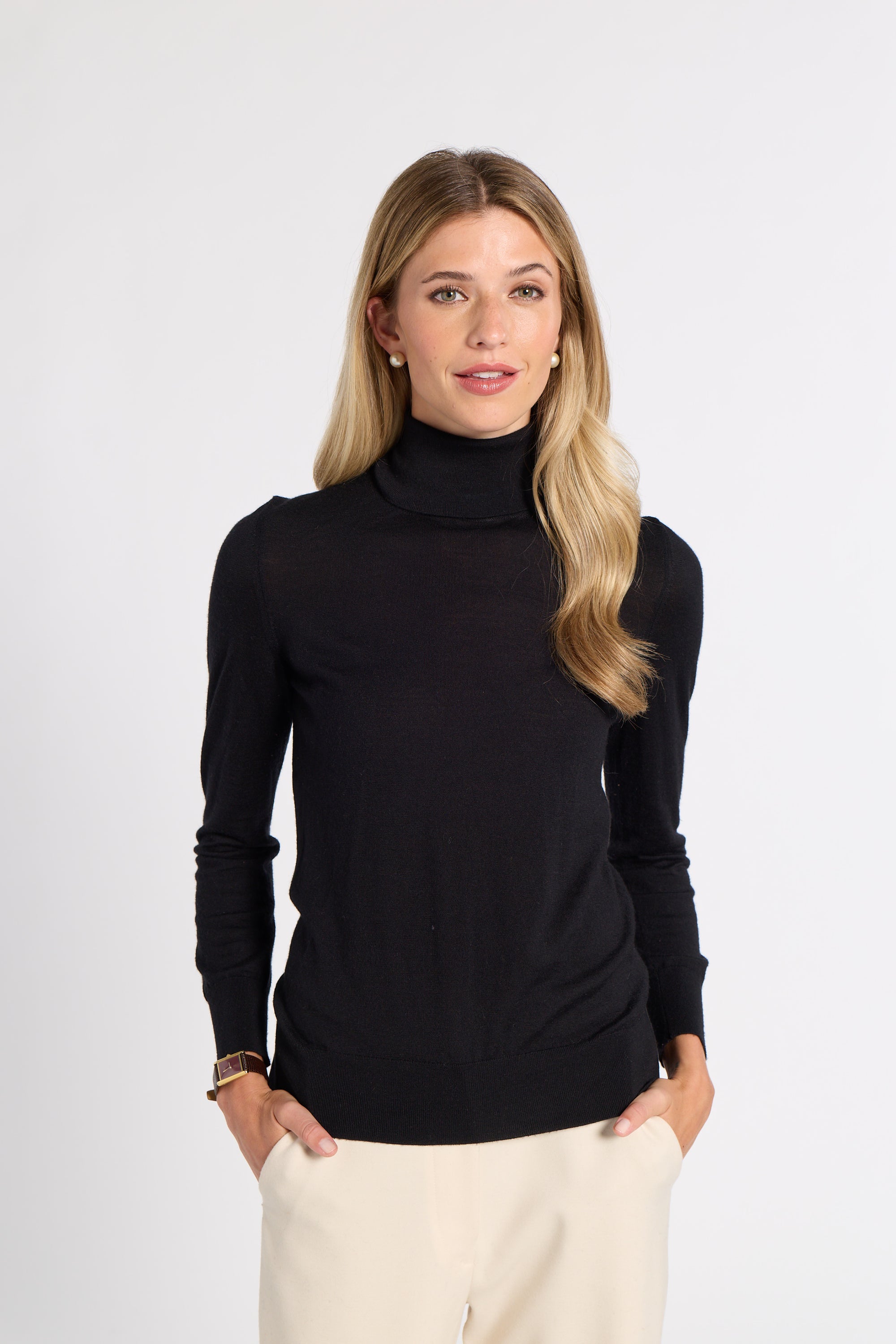 Woman modeling a black tissue turtleneck on a white background