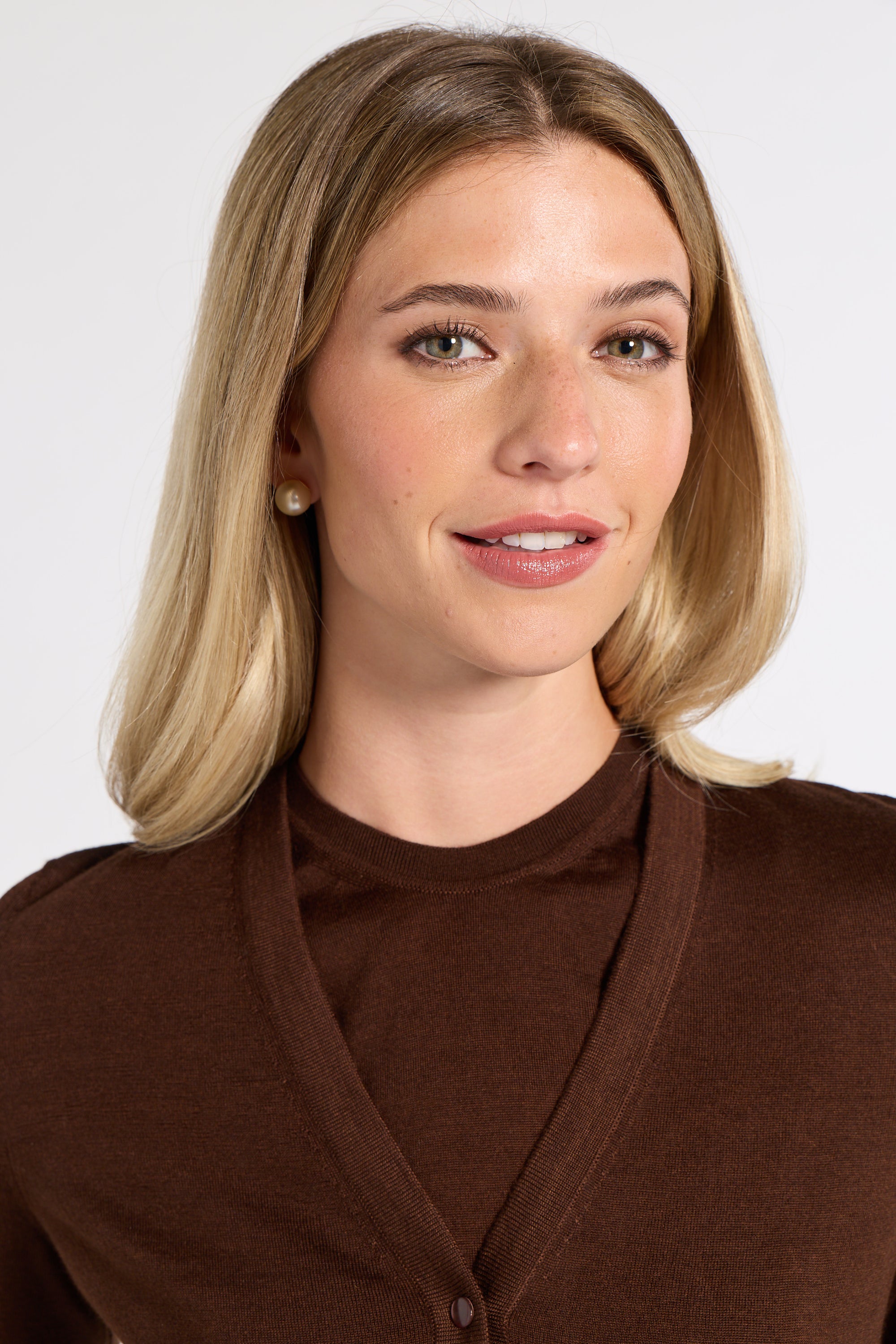 Close up of a woman wearing a tissue cardigan in a studio